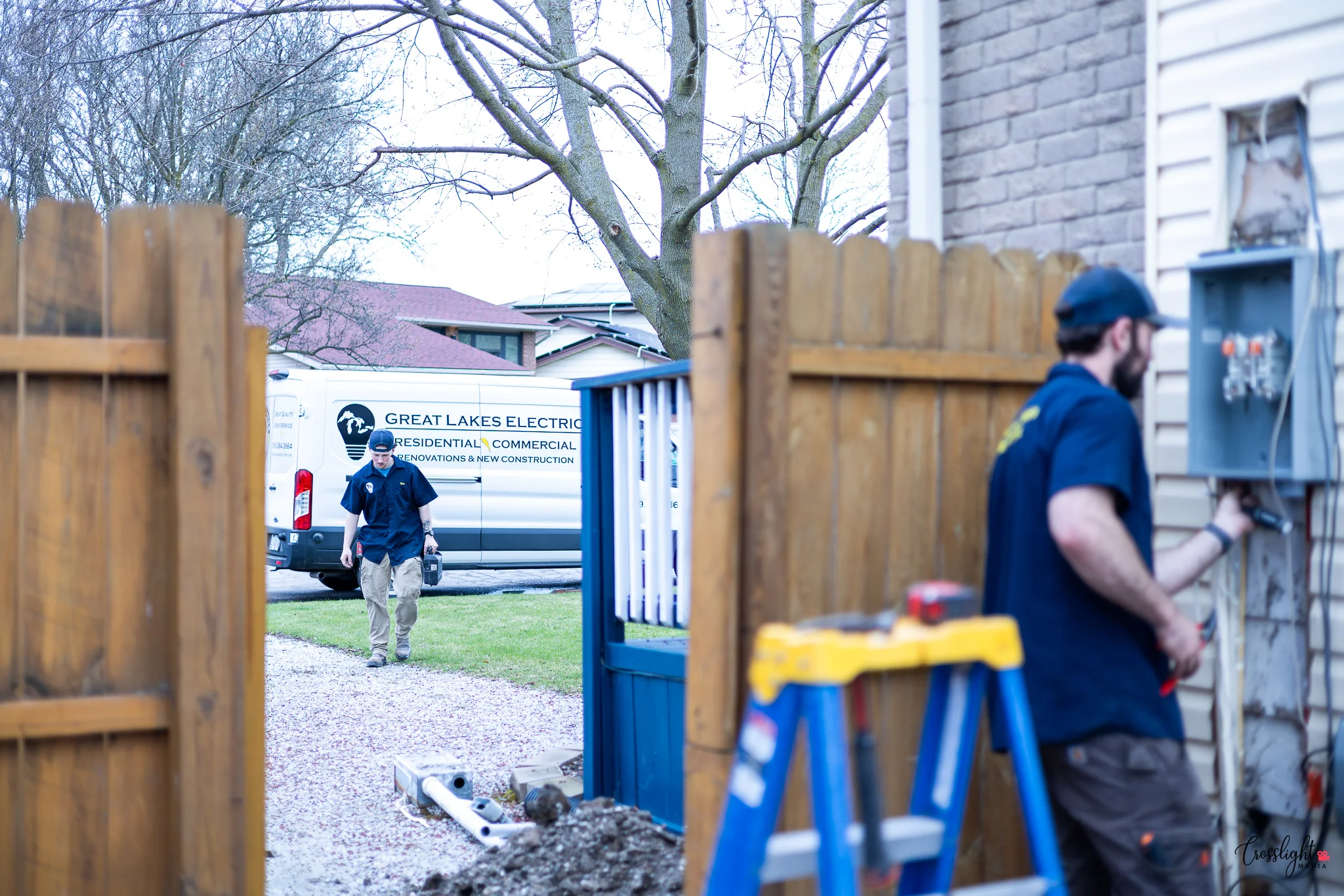 Electricians working on location with their branded business vehicle