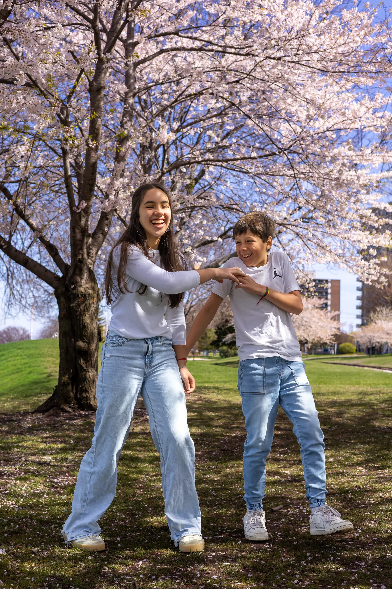 Mother playing with her children beneath spring blossoms