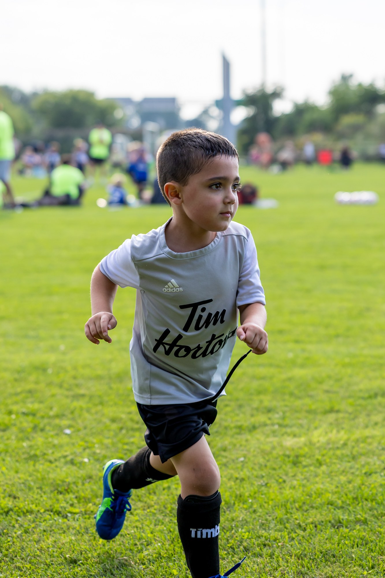 Young soccer player running across the grass during a game